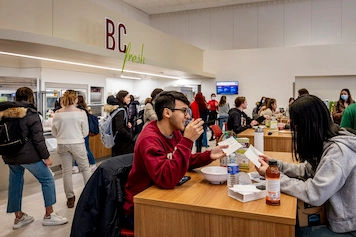 Students enjoying a meal in a busy BC dining hall.