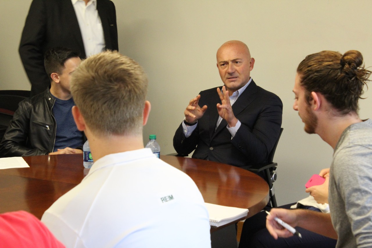 ferit sahenk speaking with students in the foreground