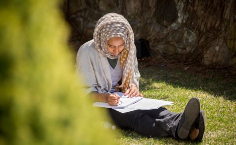 Student studying on the grass outdoors