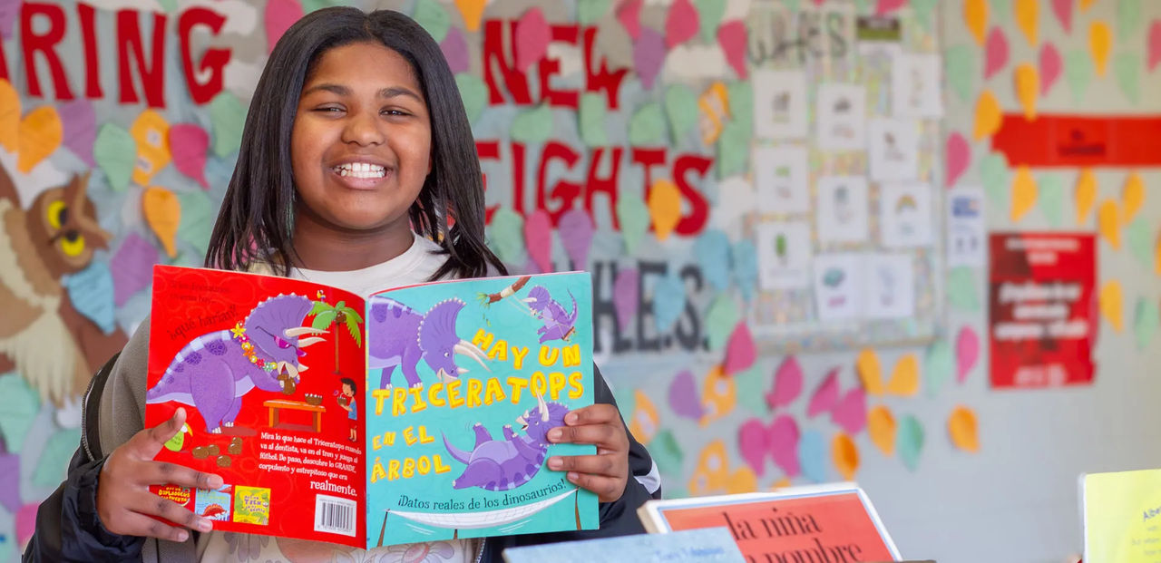 Girl smiling while holding a book