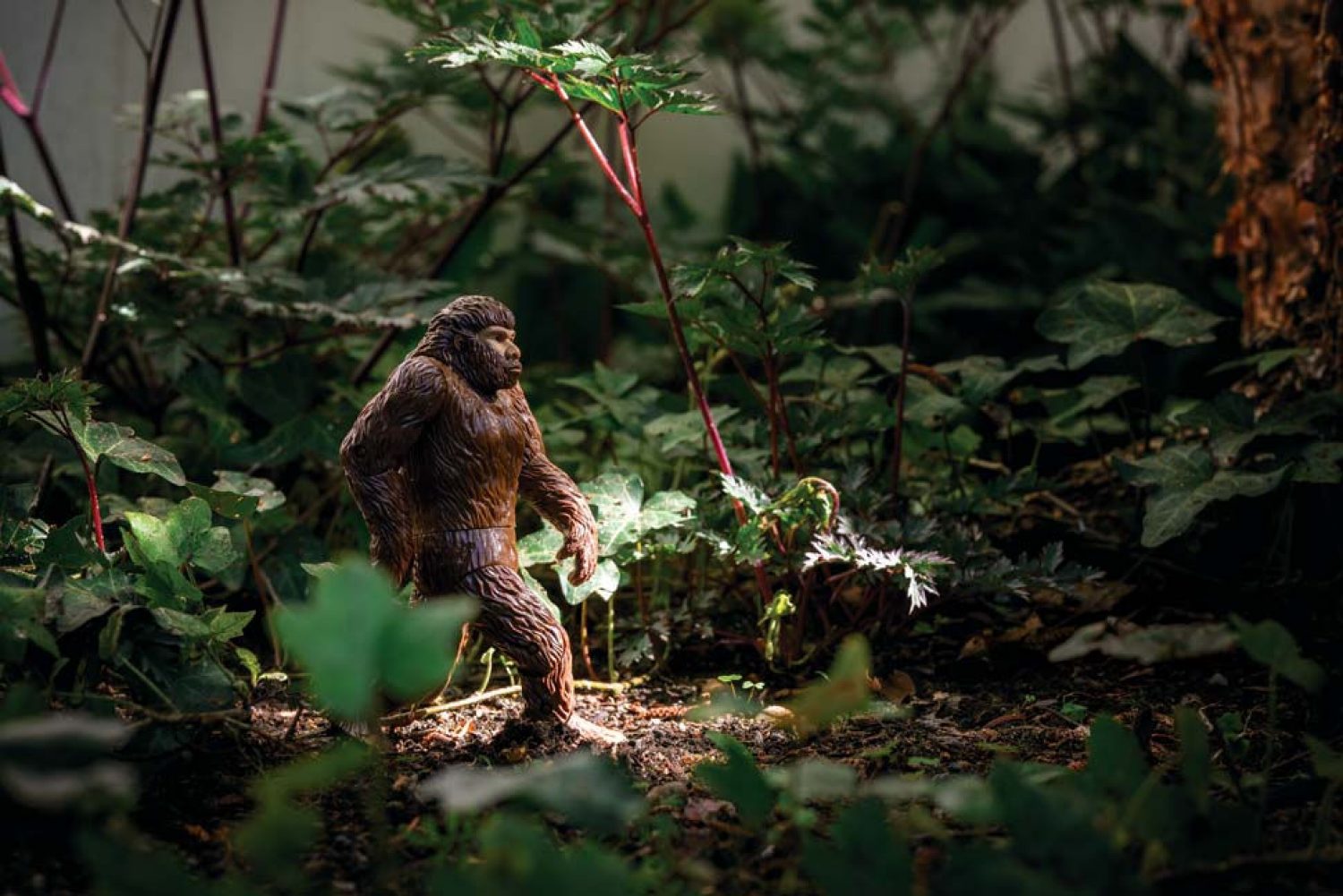 A Bigfoot toy in a mock forest setting.