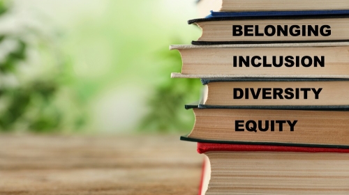 Stack of hardcover books on wooden table against blurred backgro