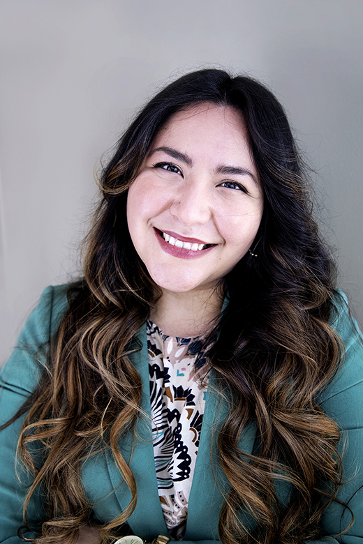 A photo of Rebecca Camargo in a teal jacket