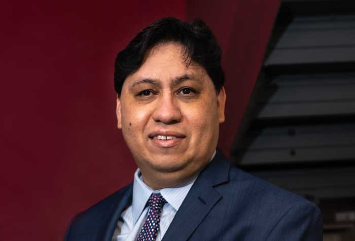 Joe Quintanilla photographed in the pressroom at National Braille Press