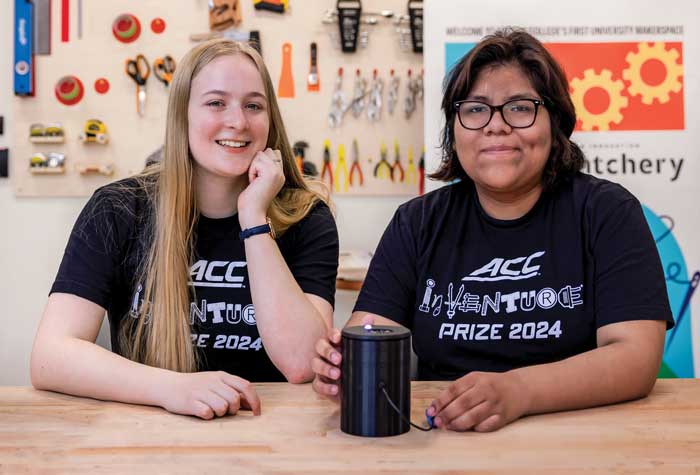 Melanie Cotta and Echo Panana photographed in the Hatchery maker space with Hue, a device they invented that identifies colors  for the visually impaired.