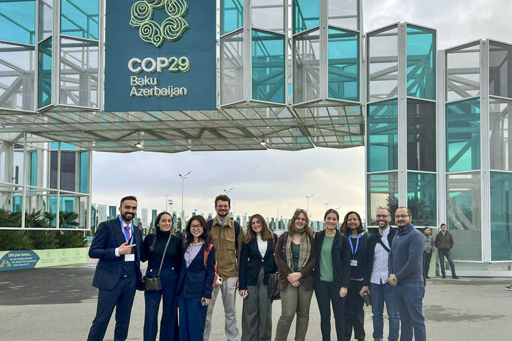 delegates in Baku in front of COP29 signage