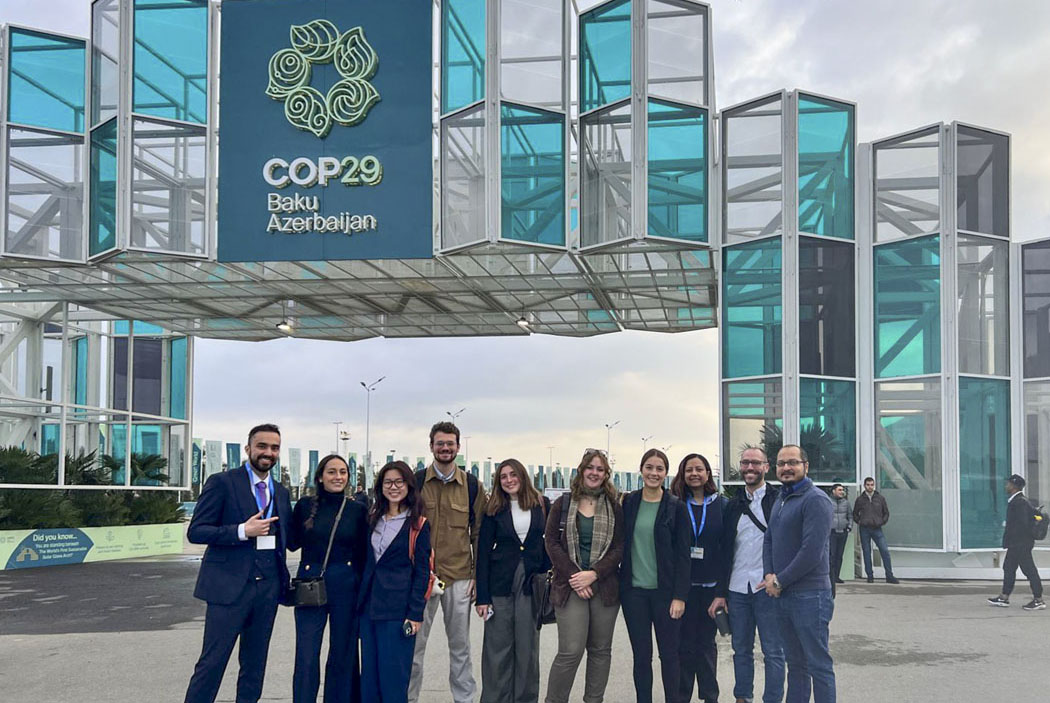 delegates in front of a COP29 sign