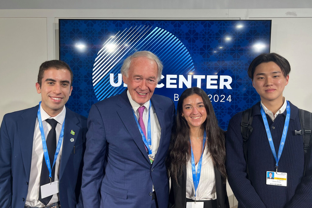 a group of students in front of COP29 signage