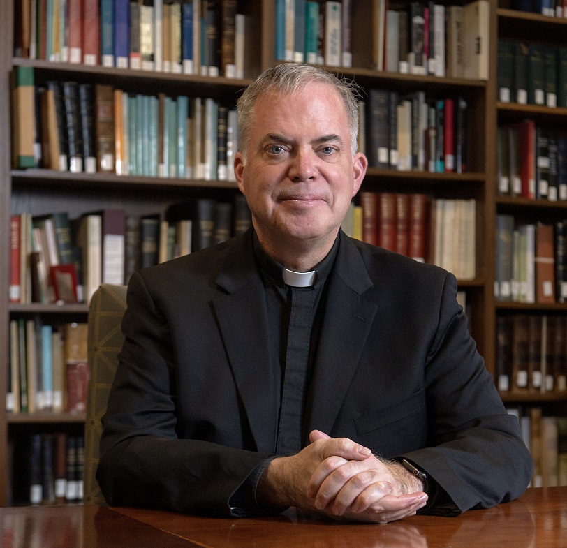 Casey Beaumier, S.J., Director, Institute for Advanced Jesuit Studies and Vice President & University Secretary photographed in an IAJS library in Simboli Hall.