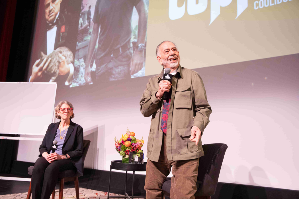 Juliet Schor and Francis Ford Coppola in front of a theater banner
